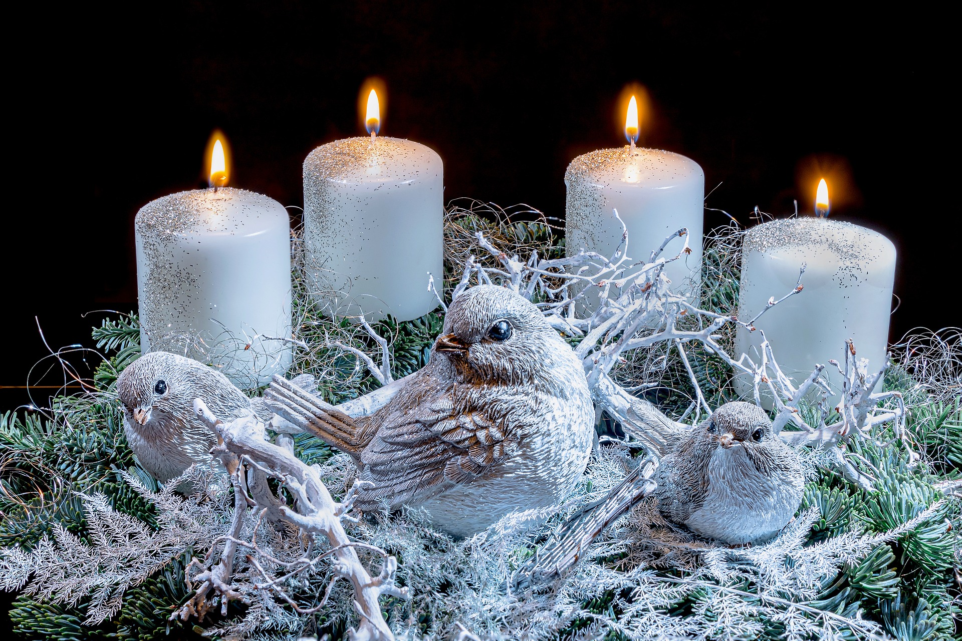 Adventkranz mit weißen Kerzen und einem weißen Vogel